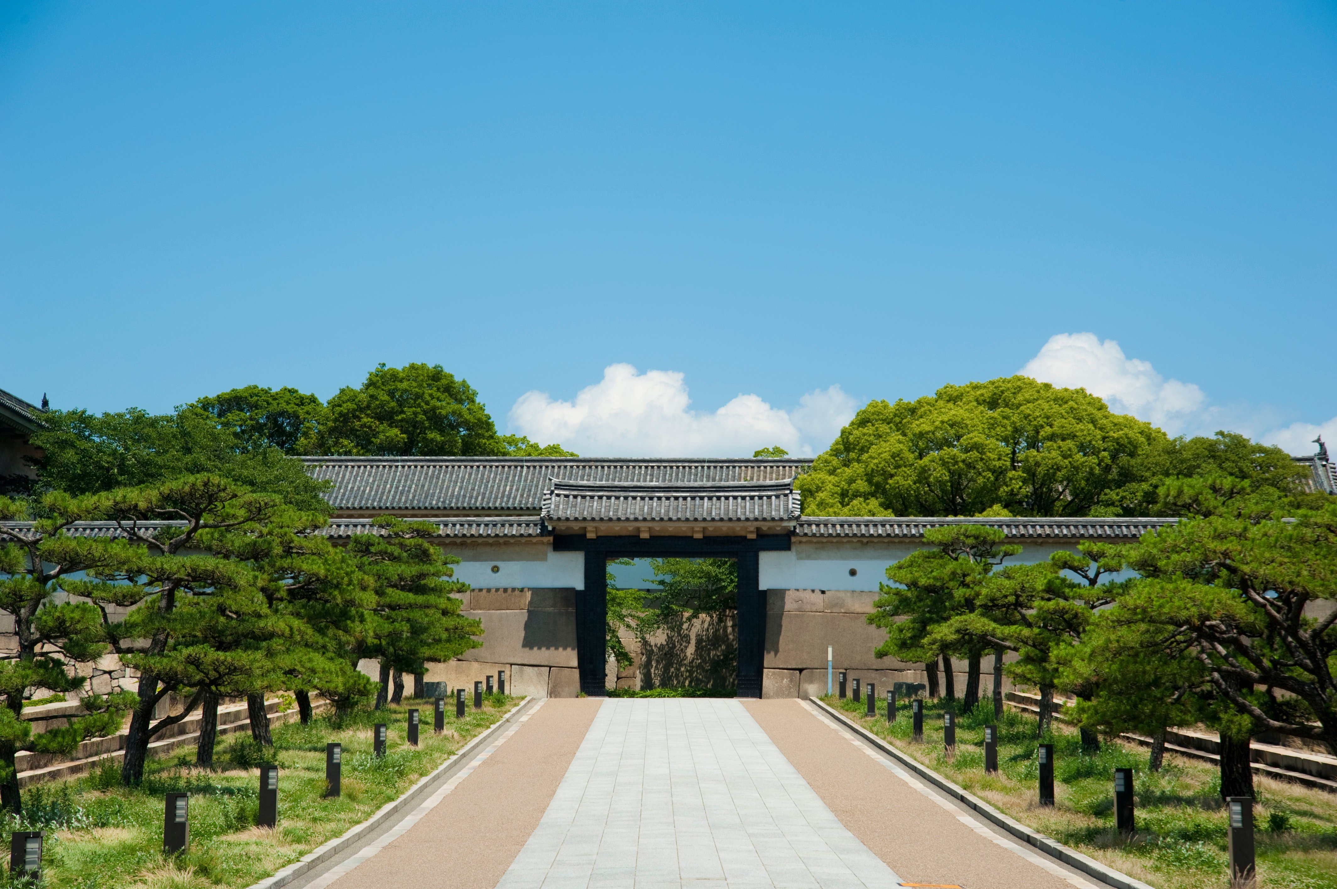 Stone pathway leading to Otemon, the main gate of Osaka Castle, flanked by pine trees