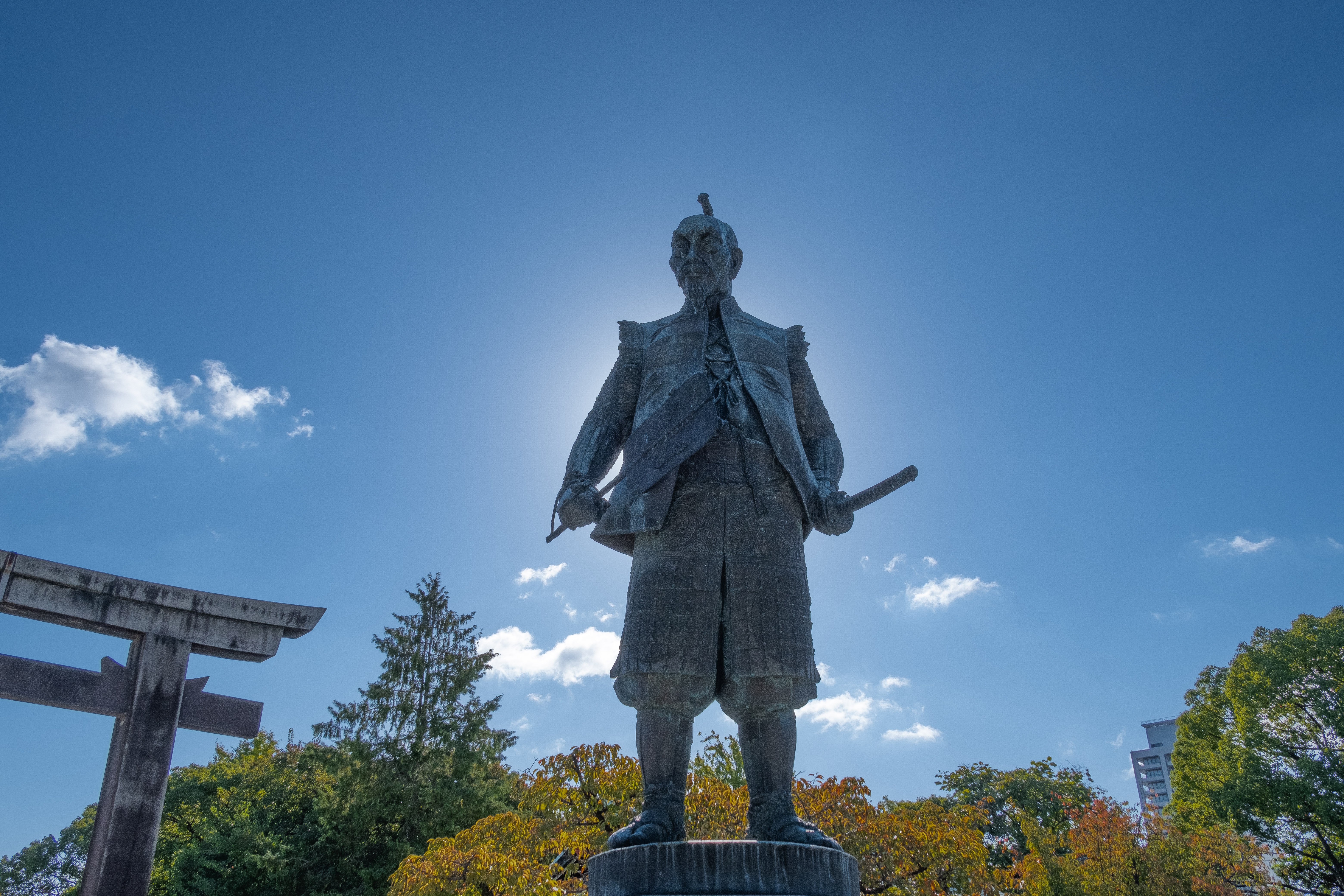 Castle10:13Claude responded: Bronze statue of Toyotomi Hideyoshi in samurai armor holding a sword, with a torii gate and autumn trees in the background near Osaka CastleBronze statue of Toyotomi Hideyoshi in samurai armor holding a sword, with a torii gate and autumn trees in the background near Osaka Castle.