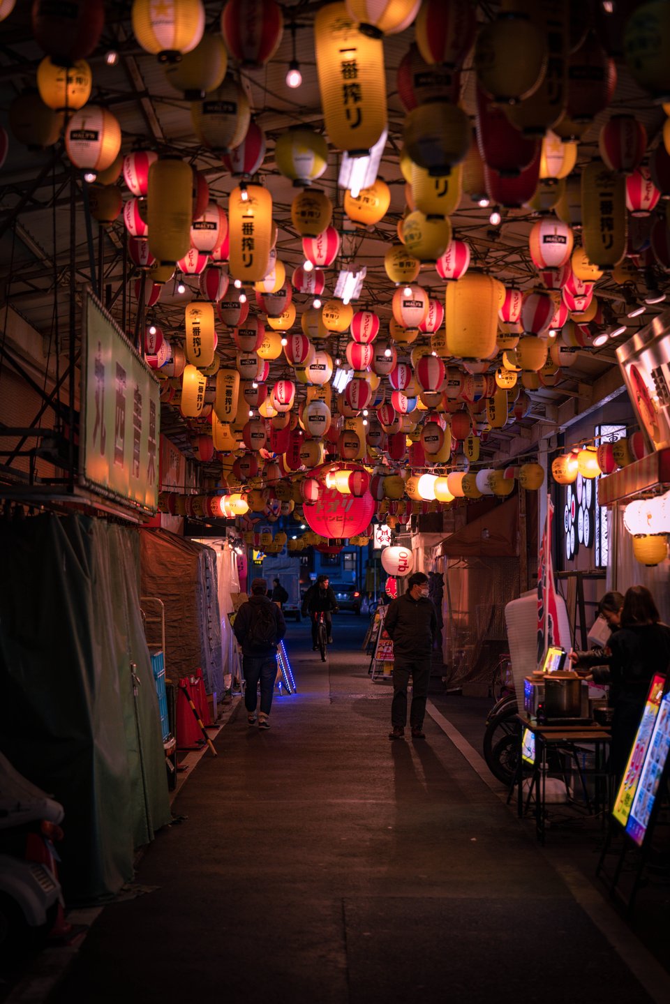 Lantern-lit alley in Tenma, Osaka, lined with small bars and izakayas at night.