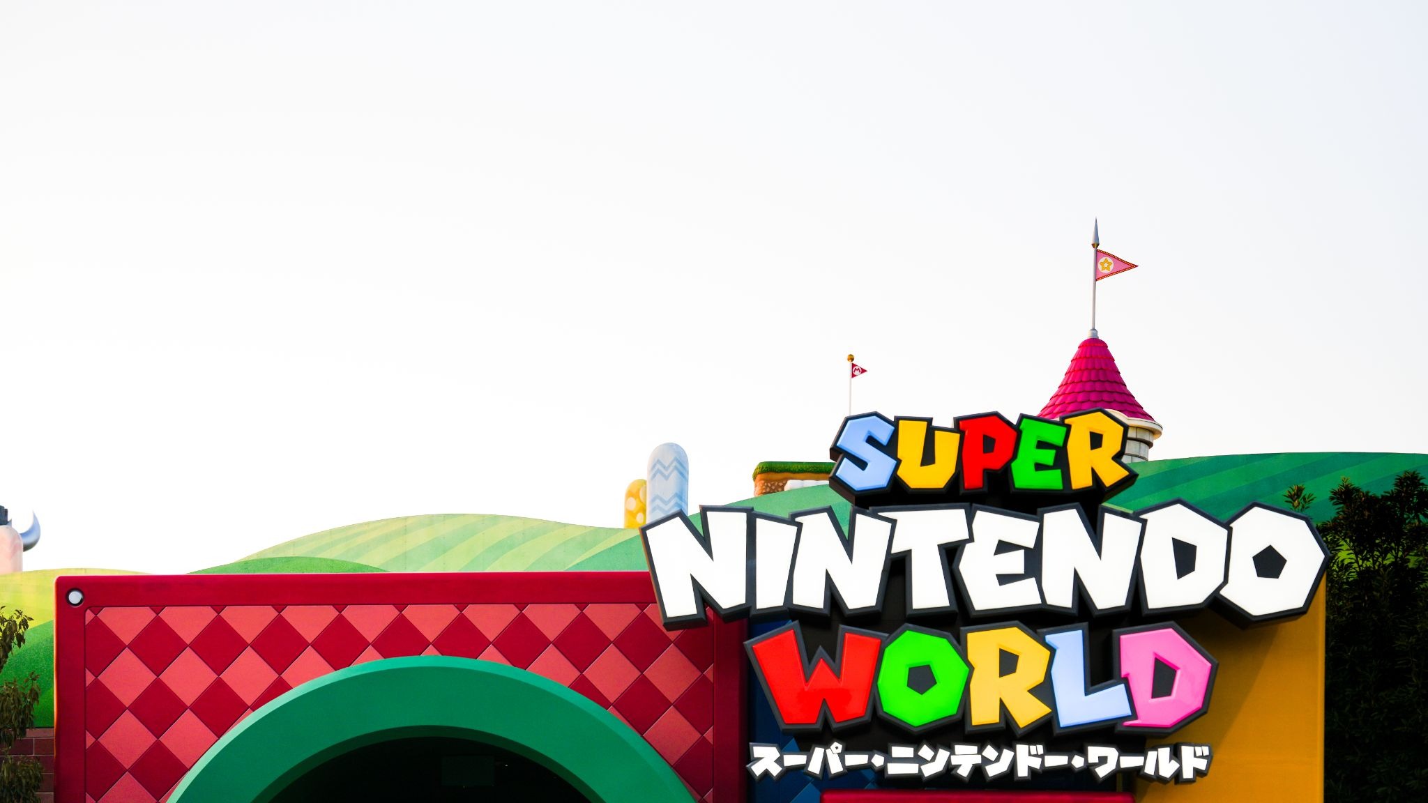 SUPER NINTENDO WORLD entrance at Universal Studios Japan in Osaka, featuring the colorful Nintendo-themed sign and landscape.