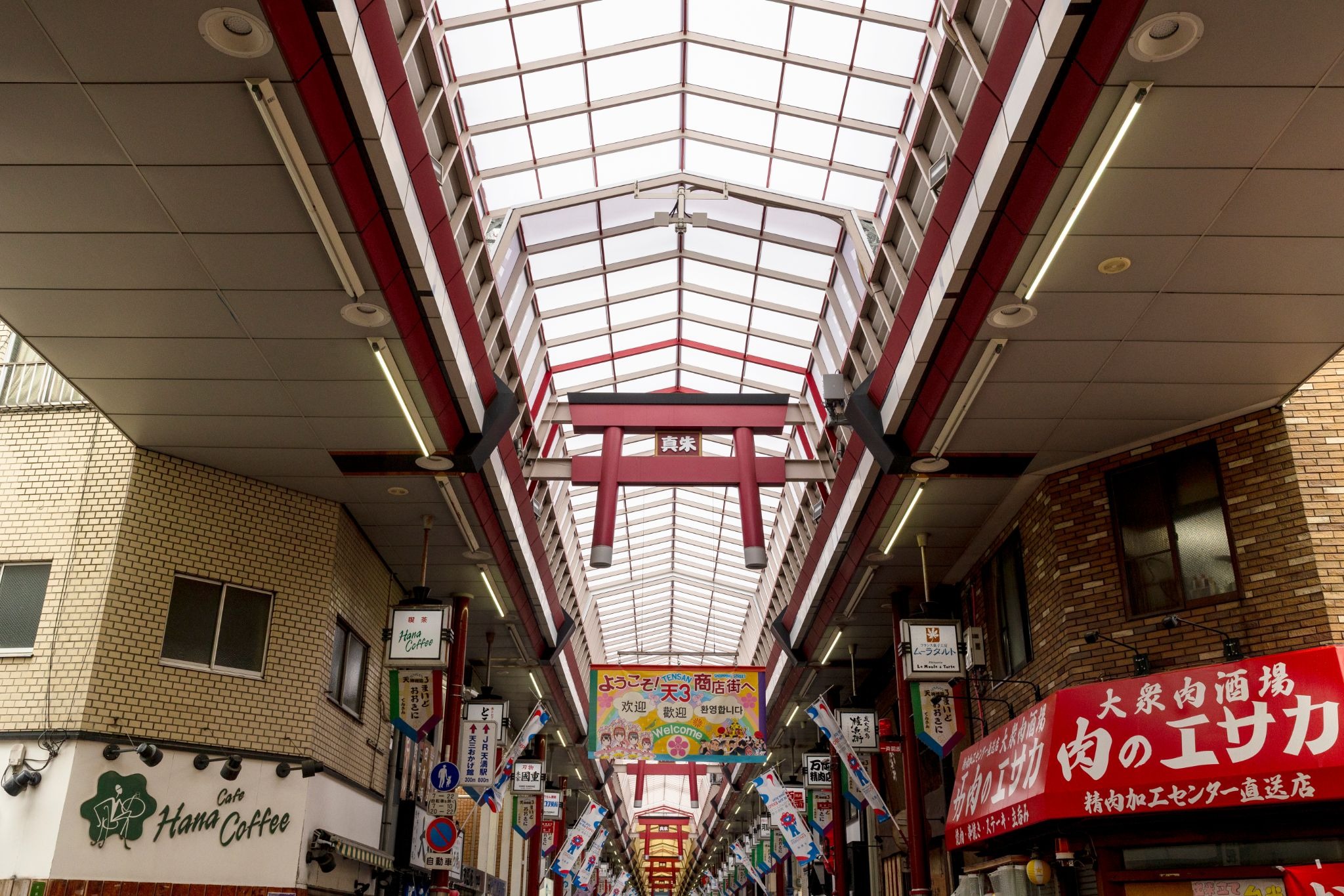 Tenjinbashisuji Shopping Street in Osaka, a covered arcade lined with local shops, restaurants, and cafés.