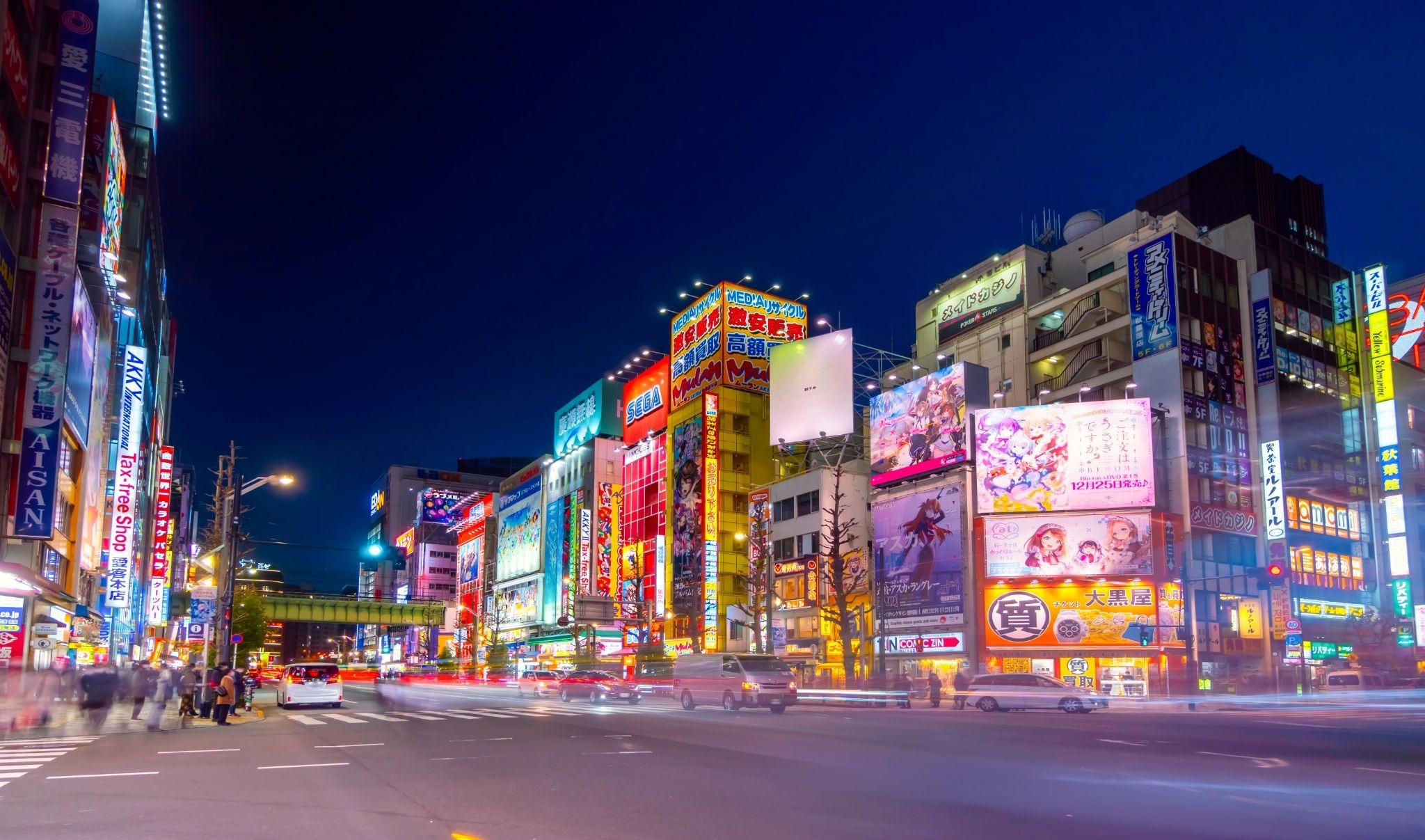 Den Den Town in Nipponbashi, Osaka, illuminated at night with anime, electronics, and gaming stores.