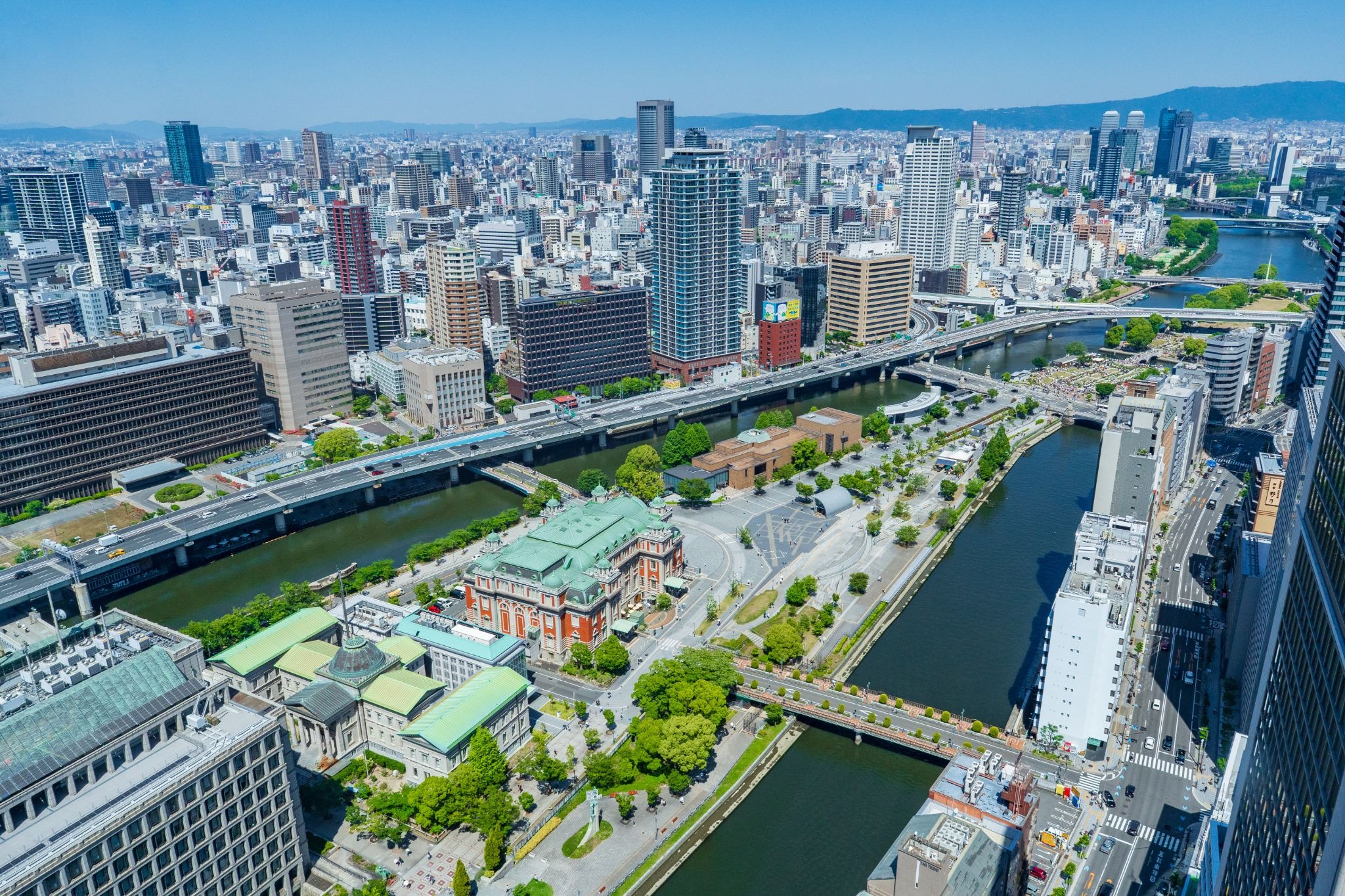 Nakanoshima waterfront in central Osaka, featuring riverside greenery, historic architecture, and the city skyline.